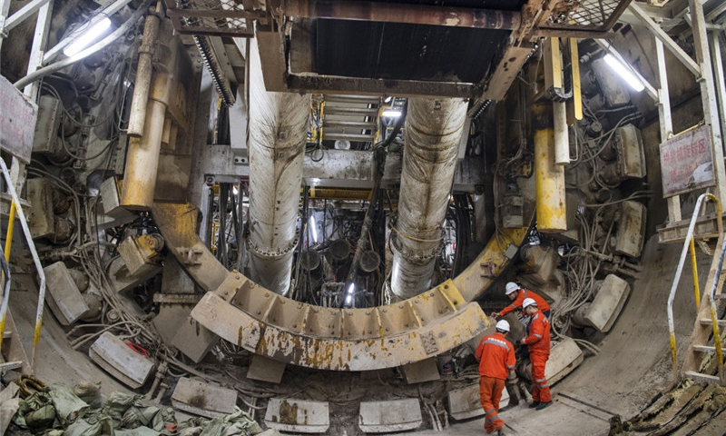 圖為2018年1月25日，參建人員在檢查即將出洞的大斷面馬蹄形盾構(gòu)機(jī)。這臺(tái)馬蹄形盾構(gòu)機(jī)能極大提高隧道空間利用率、降低施工成本和縮短施工工期。（新華社記者 陶明 攝）