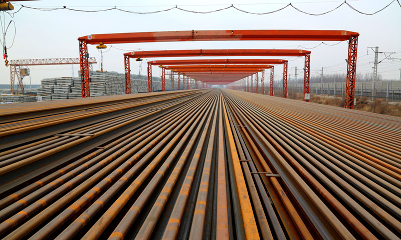 據(jù)悉，該高鐵所鋪設(shè)的鋼軌，是100米長(zhǎng)、60公斤的高鐵鋼軌，事先在焊軌基地焊成的500米長(zhǎng)的無(wú)縫鋼軌，這也是目前國(guó)內(nèi)高鐵線路廣泛采用的。這種無(wú)縫鋼軌，可以減少輪軌接觸的應(yīng)力，改善車(chē)輛動(dòng)力學(xué)的性能，能夠保證動(dòng)車(chē)組列車(chē)在線路上安全平穩(wěn)高速運(yùn)行。圖為中鐵十四局集團(tuán)通遼客專項(xiàng)目存軌基地。（攝影 肖永順）