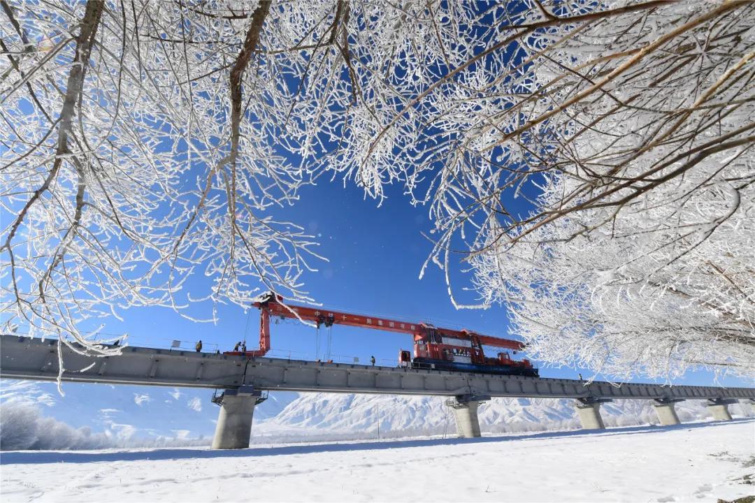 據(jù)悉，拉林鐵路自2017年10月19日開始鋪架以來，全線有1200多人參建，中鐵十一局集團(tuán)創(chuàng)新開發(fā)的“視頻領(lǐng)航”、實(shí)時(shí)監(jiān)控、列車報(bào)警、隧道內(nèi)機(jī)車定位等功能極大的保證了運(yùn)輸安全，為同類型鐵路積累了長大隧道群鋪架施工的寶貴經(jīng)驗(yàn)。圖為施工人員冒著風(fēng)雪進(jìn)行鋪架作業(yè)。