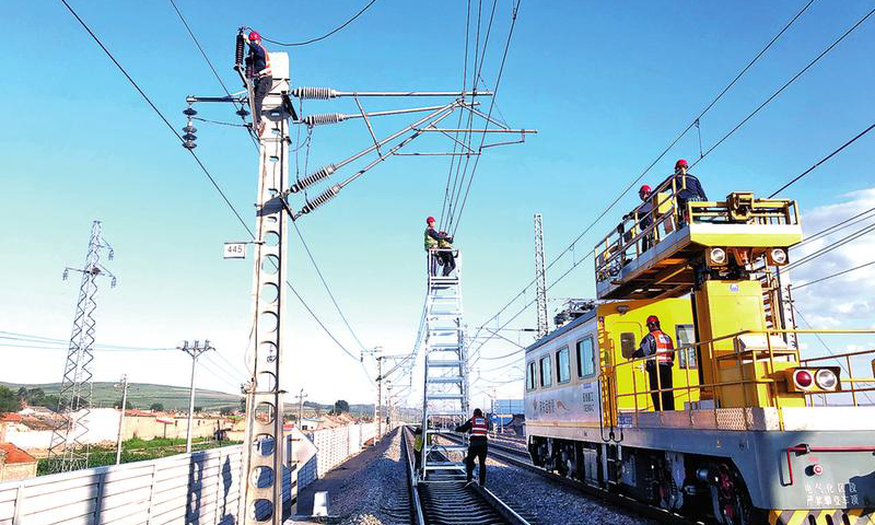 由于近期機(jī)車高位運(yùn)行，取流大，國(guó)家能源集團(tuán)包神鐵路集團(tuán)神朔鐵路公司三岔站區(qū)供電車間同時(shí)使用軌道車、梯車、人工作業(yè)，對(duì)上網(wǎng)點(diǎn)、并網(wǎng)點(diǎn)、關(guān)節(jié)電聯(lián)接主導(dǎo)電回路進(jìn)行專項(xiàng)檢修整治，成立干部包保小組，扎根一線檢查督導(dǎo)“天窗”集中修全過(guò)程，確?！疤齑啊奔行奁陂g對(duì)接觸網(wǎng)主導(dǎo)電回路檢修有序可控。圖為7月14日，接觸網(wǎng)檢修現(xiàn)場(chǎng)。