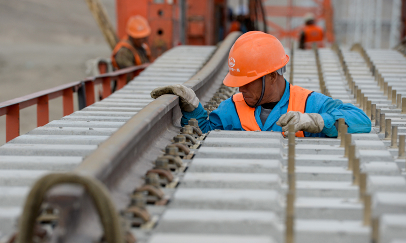 圖為7月18日，中鐵一局的施工人員在檢查軌排。（新華社記者 丁磊 攝）