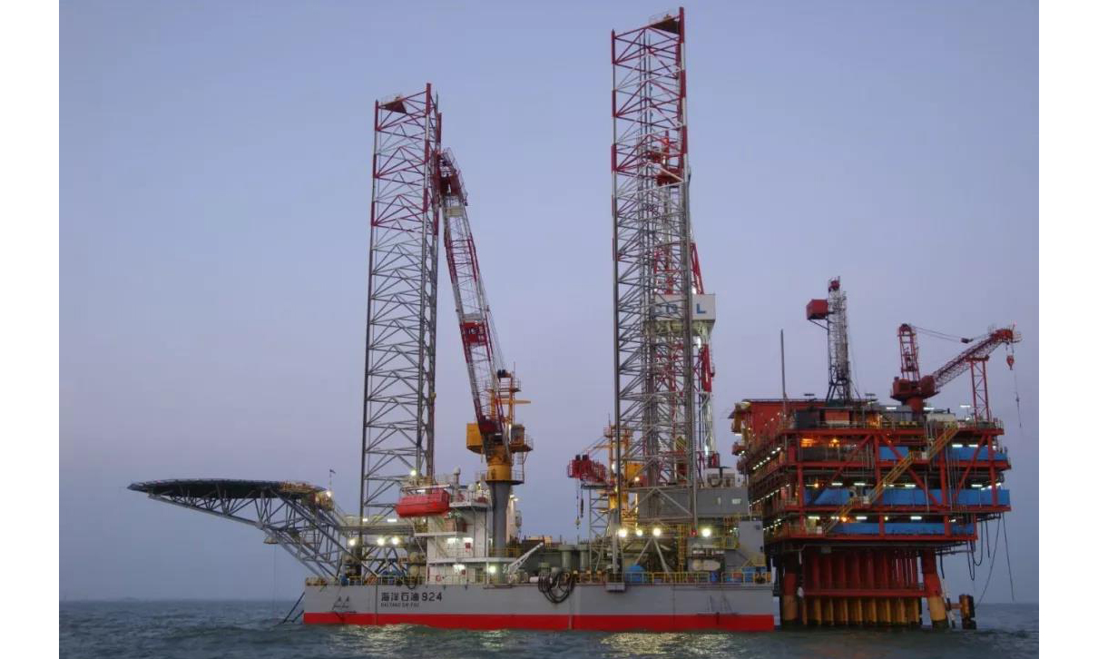 第一種是插樁定位。“假裝漂著”的鉆井平臺——自升式鉆井平臺，通過樁腿的升降在海底“扎根”，并確保船體始終“探出水面”，穩如泰山。如果這種平臺想要移動，那么就需要圖中的拖輪拖著走，拖航狀態下，平臺船體漂浮，樁腿高聳。抵達目標井位后，鉆井平臺找好位置就開始下放樁腿，重量逐漸由浮力支撐轉變為樁腿支撐。