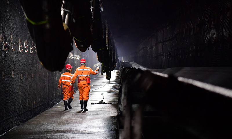 為了駕馭這些“鋼鐵巨獸”，神東煤炭集團派出了一支平均年齡35歲、大專及以上學歷員工占78%的精英隊伍——上灣煤礦綜采一隊。他們通過協作和努力，使上灣煤礦在采煤工效、成本、生產能力、生產安全等方面躋身世界一流水準。圖為11月26日，在上灣煤礦12402綜采面內，工作人員沿著輸送帶進行巡視。（新華社記者 邵瑞 攝）