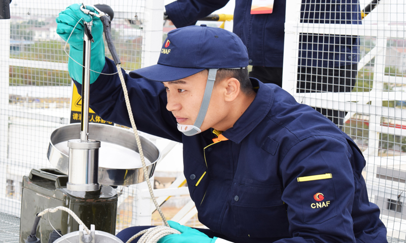 圖為選手測量罐內油品油溫。 