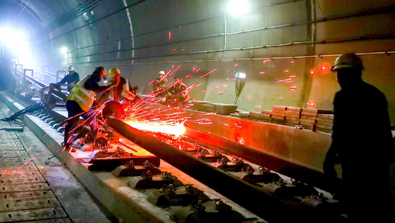 成貴高鐵鋪軌要克服長大坡道對機車牽引制動和運輸安全的影響，全線線路坡度大于15‰的地段累計28處，共128.8公里，其中長達12.5公里30‰的長大坡道，直接落差達到464.5米。圖為工人切割鋼軌。