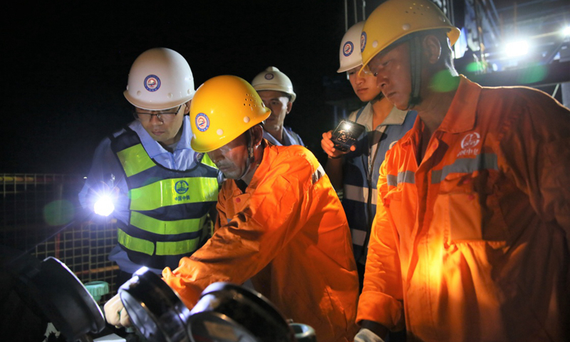 圖為7月28日，中國中鐵八局建設者在中老鐵路老撾瑯勃拉邦湄公河特大橋上向最后一個合龍節段澆筑混凝土，進行大橋合龍工作。新華社發（熊天澤 攝） 
