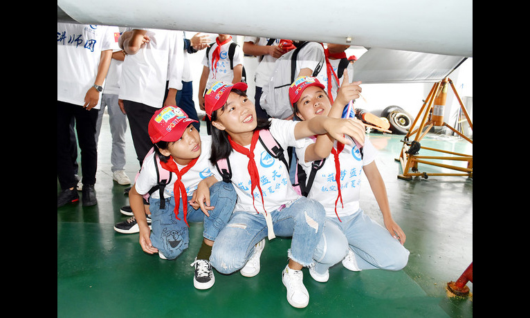 近日，航空工業集團貴飛黨委舉辦航空工業定點扶貧貴州四縣“筑夢藍天”夏令營航空科普活動，組織定點幫扶學校的優秀學生代表前往貴飛部裝分廠，參觀飛機的生產制造過程，感受現代軍工崛起，開闊學生眼界，激發航空熱情，營造全民知航空、愛航空的濃厚氛圍。圖為學生近距離觀看飛機零件。