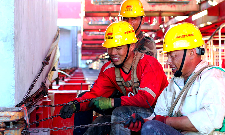 圖為工作人員調整最后一片鐵路節段梁。