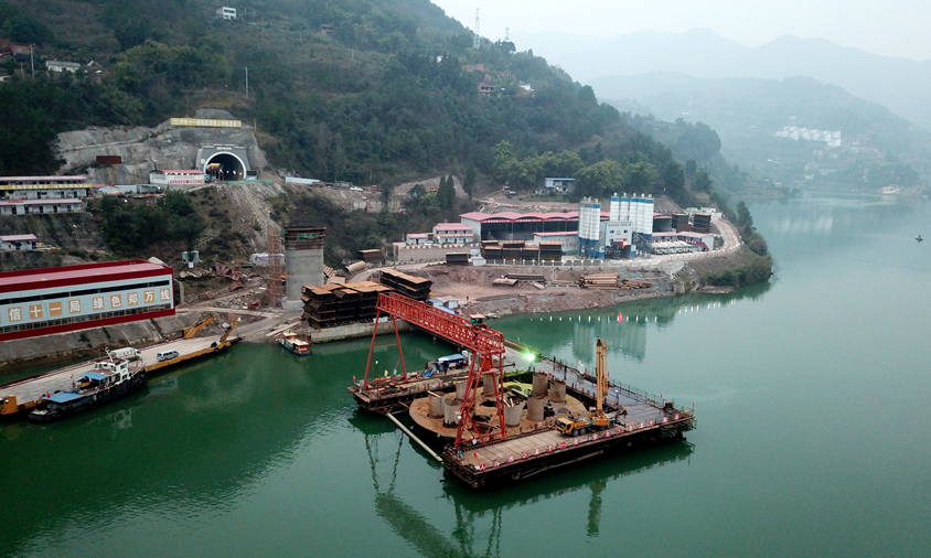 這次澆筑的10號橋墩承臺，比長江最低水位線還要低5.4米，整個施工都在水中的鋼圍堰內進行，難度非常大。在施工中，中鐵十一局鄭萬項目組面臨要保證持續通航、下棧橋時水位漲落變化等難題。圖為鄭萬高鐵彭溪河多線特大橋施工現場。（劉興敏 攝）