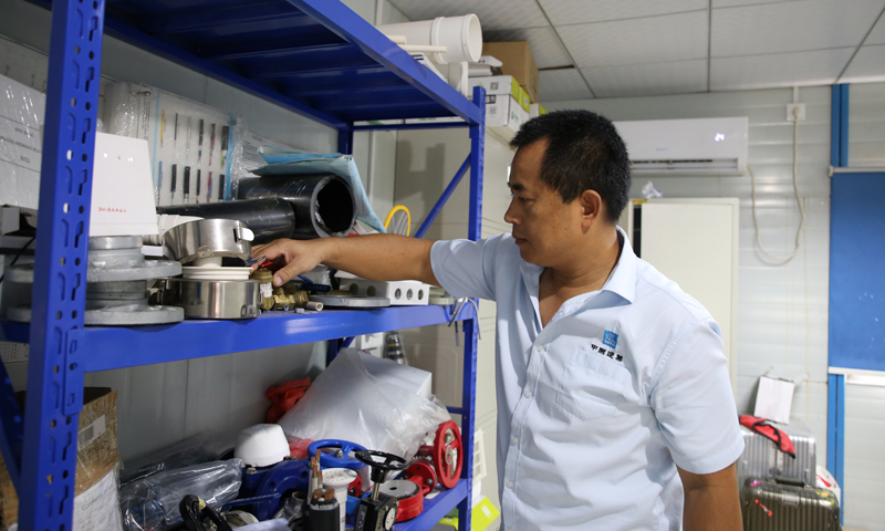 圖為馬爾代夫胡魯馬累島的公益住房項目施工現場辦公室，中建三局馬爾代夫公益住房項目機電安裝負責人龍太平檢查來自中國的建筑施工材料樣品。（新華社記者 朱瑞卿 攝）