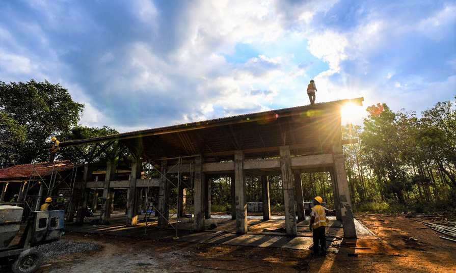 當(dāng)?shù)毓と苏谙﹃?yáng)下的公益課堂項(xiàng)目工地施工。