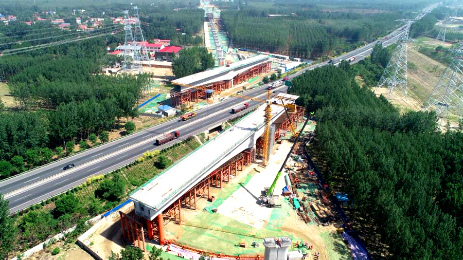 5月25日凌晨5時，經(jīng)過一夜的奮戰(zhàn)，京雄城際鐵路重難點控制工程——固安特大橋跨廊涿高速公路72+128+72m墩頂不平衡轉(zhuǎn)體連續(xù)梁成功完成轉(zhuǎn)體，這是京雄城際鐵路建設(shè)取得的突破性建設(shè)成果。圖為轉(zhuǎn)體前連續(xù)梁在高速公路兩側(cè)分節(jié)段澆筑。