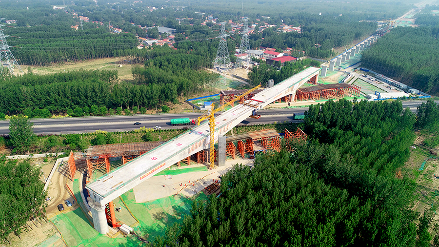 據(jù)悉，固安特大橋跨廊涿高速連續(xù)梁主跨長128米，分節(jié)段在廊涿高速公路兩側(cè)支架現(xiàn)澆完成后，采用墩頂平轉(zhuǎn)法，雙向并行勻速逆時針轉(zhuǎn)體39.5度完成梁體合龍，梁體轉(zhuǎn)體重量約為9000噸，轉(zhuǎn)體梁在下滑道上走行距離為52.7米。圖為轉(zhuǎn)體完成。