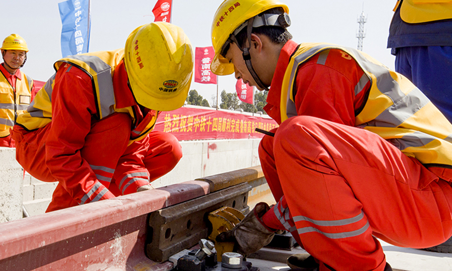 據(jù)悉，魯南高鐵日曲段靜態(tài)驗(yàn)收預(yù)計(jì)持續(xù)1個(gè)月左右，靜態(tài)驗(yàn)收結(jié)束后將進(jìn)行動(dòng)態(tài)驗(yàn)收、聯(lián)調(diào)聯(lián)試、動(dòng)態(tài)檢測(cè)及運(yùn)行試驗(yàn)等，有望在年底前開通運(yùn)營(yíng)。圖為中鐵十四局鋪軌工人進(jìn)行鋼軌龍口固定工作。