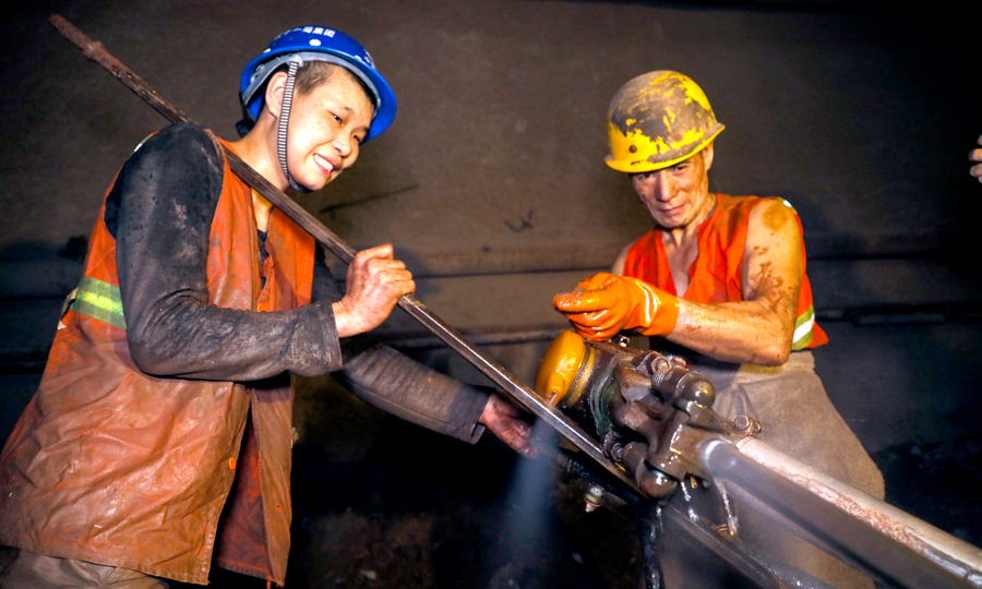 鐵峰山隧道下穿一段大型煤礦采空區，里面充滿水和泥水混合物多達20萬方，中鐵十一局與中鐵二十五局通過編制安全技術交底和專項應急預案等多種措施，最終安全通過采空區。圖為施工人員克服隧道內惡劣環境鉆孔作業。（鄒飛 攝）
