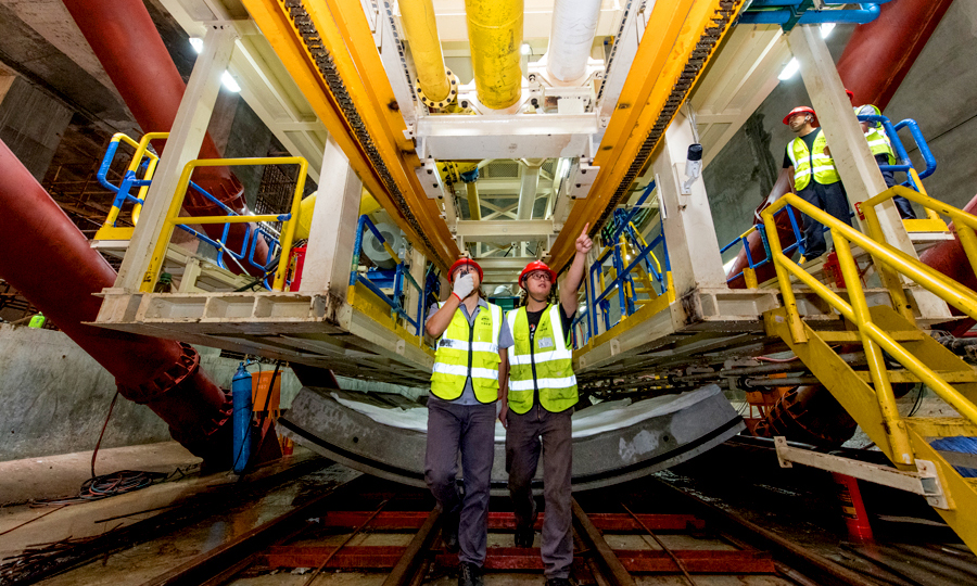 近日，中國鐵建所屬中鐵二十二局軌道公司廣州地鐵18號和22號線項目通過加長洞門鋼環(huán)寬度，在鋼環(huán)內(nèi)圈安裝盾尾密封刷進行注脂，實現(xiàn)了洞門雙重止水效果，有效克服了廣州市富水沙層盾構(gòu)始發(fā)的技術(shù)難題。日前，該項目部首臺大直徑泥水盾構(gòu)機始發(fā)。圖為技術(shù)人員在討論解決方案。（桂天奇 攝）