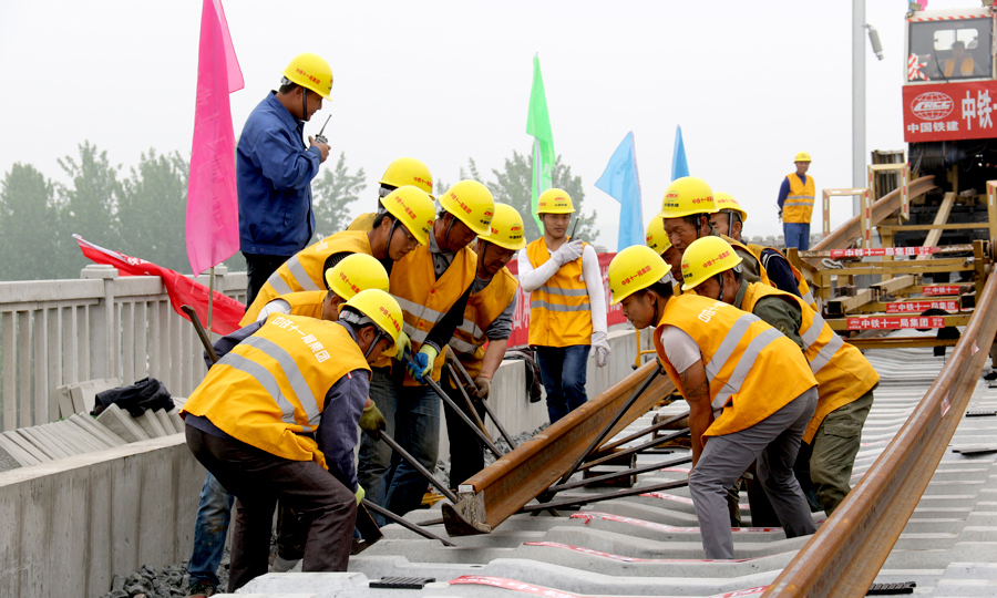 徐宿淮鹽鐵路全線采用500米長鋼軌鋪設(shè)，按一次性鋪設(shè)、跨區(qū)間無縫線路設(shè)計，長軌鋪設(shè)完成后還需進行多種作業(yè)確保軌面平順度標(biāo)高0.2毫米左右，提高了線路的平順性，確保行駛安全，讓旅客乘坐更加平穩(wěn)舒適。圖為作業(yè)人員引導(dǎo)鋼軌向前推送。