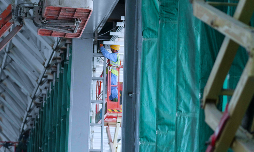 中建裝飾幕墻施工團隊項目經理梁勇介紹，西安絲路國際會議中心建設最大的難點就是幕墻玻璃吊裝，玻璃幕墻鋼吊柱同時參與主體結構受力，整個玻璃幕墻懸掛在主體結構之上，幕墻的結構處于動態變化之中。圖為施工現場一隅。（北京電視臺 楊曉春 攝）