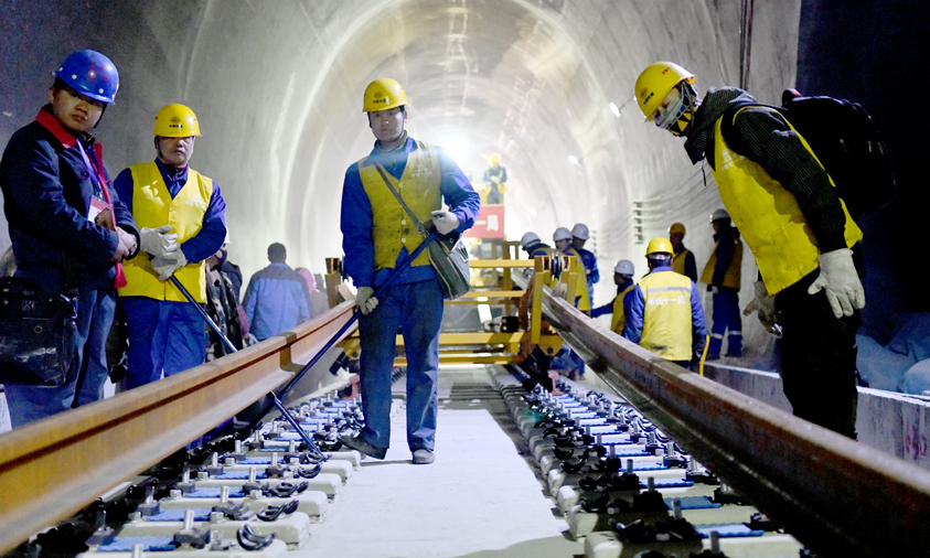 據(jù)介紹，拉林鐵路路基、橋梁為有砟軌道，鋪軌采取先鋪短軌排再換長(zhǎng)鋼軌的換鋪法，香嘎山隧道是拉林鐵路首次采用長(zhǎng)鋼軌鋪設(shè)的隧道。圖為工作人員在香嘎山隧道鋪設(shè)長(zhǎng)鋼軌。