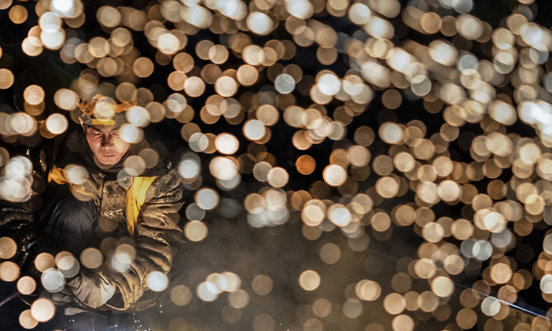 圖為1月15日凌晨，中鐵十一局施工人員在西安站改擴(kuò)建工程現(xiàn)場(chǎng)切割鋼軌。（新華社記者 陶明 攝）