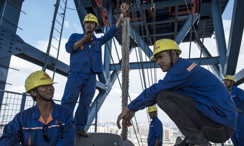 6月25日，劉能（左二）在工作間隙與工友小憩。（新華社記者 肖藝九 攝）