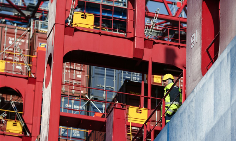 2月23日，在德國漢堡港，一名工作人員在集裝箱船“中遠海運白羊座”號上參與集裝箱卸載工作。（新華社記者 單宇琦 攝）