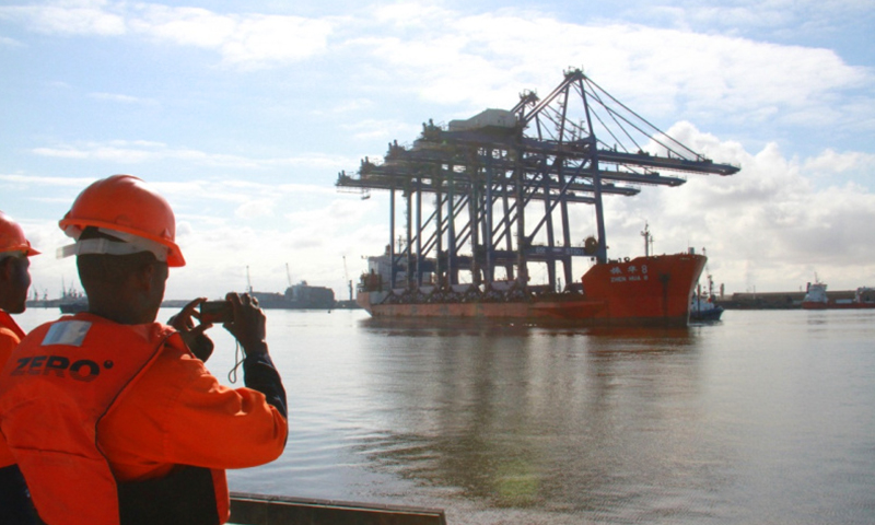 載著四臺巨大岸橋的貨輪9日上午緩緩靠向正在建設的納米比亞沃爾維斯灣集裝箱碼頭。納米比亞港務局工作人員等候運載著四臺岸橋的貨輪靠港。（新華社記者 吳長偉 攝）