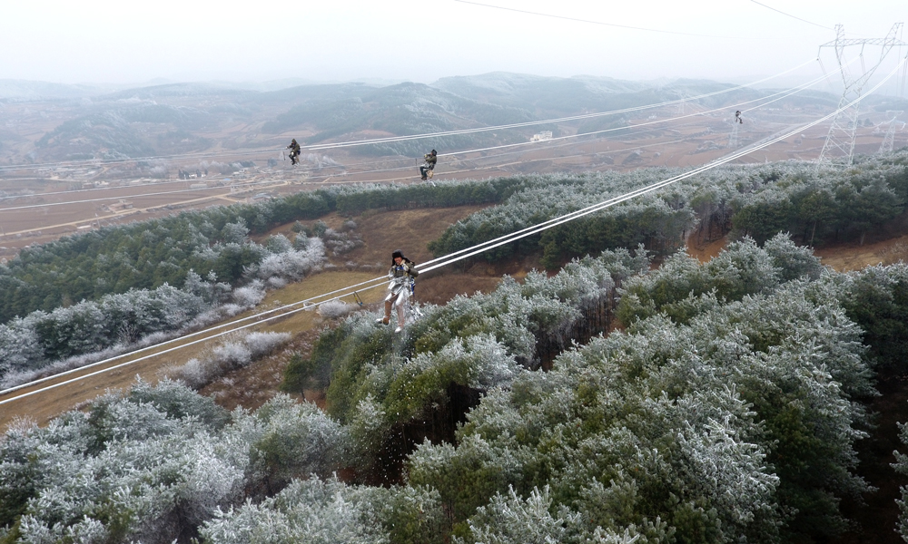 2018年1月22日起，我國遭遇今冬以來范圍最廣、持續時間最長、影響最嚴重的一次低溫雨雪冰凍天氣過程。截至1月29日17時，南方五省區共有1286條輸電線路覆冰。面對雨雪冰凍，南網人用實際行動在冰雪中筑起了一張堅強電網。圖為1月29日，南方電網云南公司施工人員冒著嚴寒加緊對昭通魯甸災后重建水電鋁220kV線路進行施工。在30多米的高空線路線路上，身上的衣服已經被白雪覆蓋。（巴曉軍 攝）