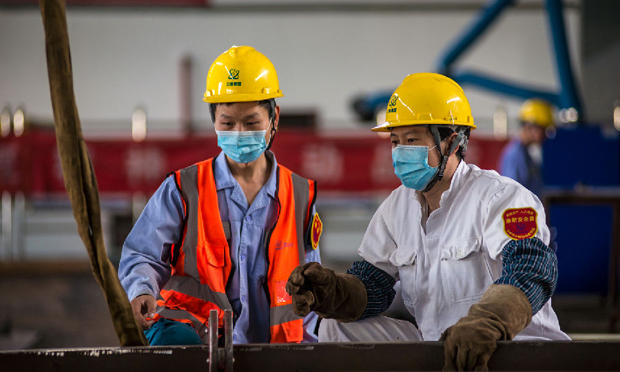 近日，中核華興鋼結構管理部濱江基地鉚工班長許鵬和焊工副班長羅中華討論卡環位置并多次試吊找準。車間內的長鋼梁吊裝需要注意的事項比較多，這些基礎工作的完成，是每一次安全吊裝作業的重要保證。一樁樁小事夯實了踏實做事的基礎，一個個細節造就了優質品控的口碑。（范錦紅 攝）