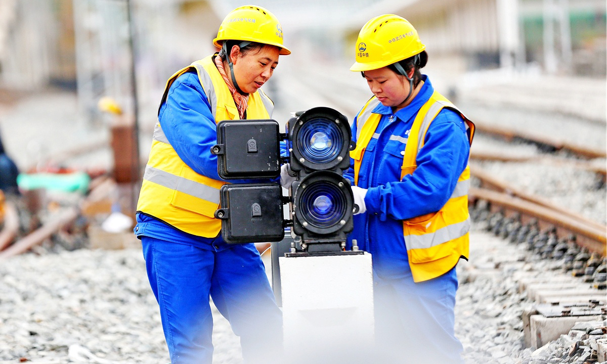 在施工現(xiàn)場，20歲的突擊隊隊員張玉倩正在專心致志地進行箱盒配線作業(yè)，分線、穿線……動作流暢連貫，猶如繡娘在穿針引線。突擊隊隊員平均年齡29歲，張玉倩是年齡最小的姑娘。她們擔負著管段內9個車站、9座信號樓的施工任務。為縮短工期，提高效率，隊員們打破常規(guī)，創(chuàng)新配線工藝，得到了專家的一致認可。圖為信號燈配線。