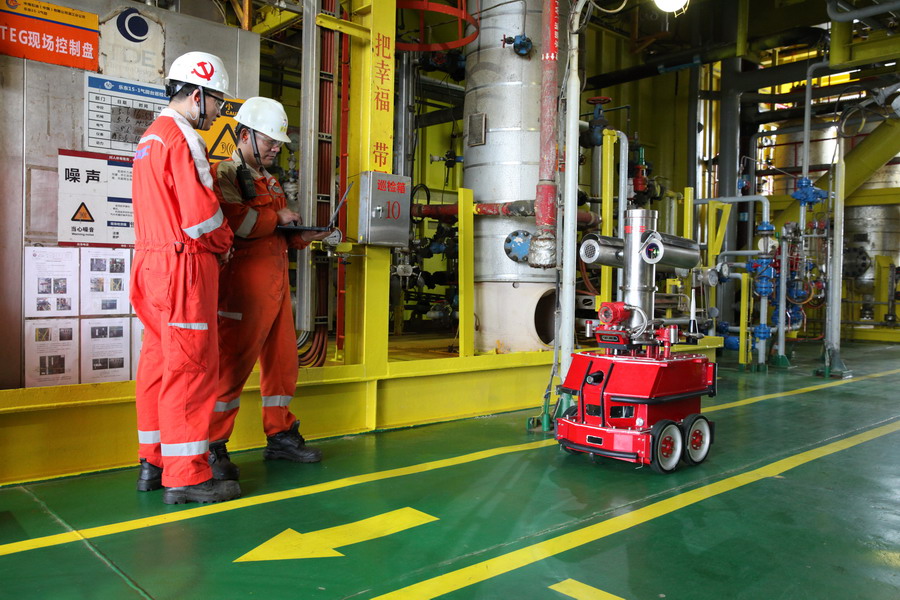 圖為氣田工作人員對智能機器人進行調試。