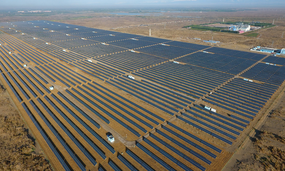 作為以節能減排、環境保護為主業的中央企業，中國節能積極發揮主業優勢和技術優勢，通過光伏治沙、生態修復等方式讓荒漠重燃生機，展現不一樣的綠色打開方式。中節能太陽能新疆區霍爾果斯光伏電站位于圖開沙漠邊緣，風沙大、植被少、工作生活環境惡劣。為了改善生活環境，從2015年開始，霍爾果斯電站連續兩年開展防風治沙工作，使用麥草在沙漠中扎成方格形狀沙障，幫助固沙。圖為中節能太陽能新疆區霍爾果斯光伏電站。