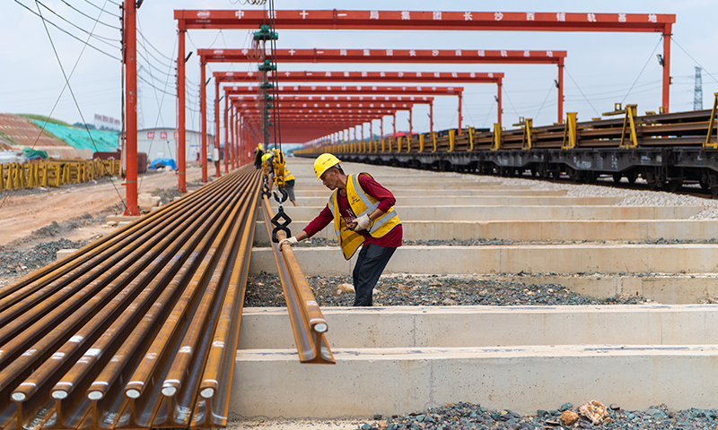 據了解，常益長鐵路線路全長約157公里，設計時速350公里，是國家“八縱八橫”高速鐵路網的重要組成部分。圖為在中鐵十一局常益長鐵路長沙西鋪軌基地，工作人員在卸載軌道。新華社記者 陳思汗 攝