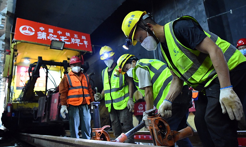 近日，鄭（州）許（昌）市域鐵路鄭州段軌道貫通。鄭許市域鐵路工程又稱鄭州機(jī)場(chǎng)至許昌市城市軌道交通工程，是一條連接鄭州市與許昌市的城市軌道交通系統(tǒng)，全長(zhǎng)67.13公里，設(shè)計(jì)時(shí)速120公里。圖為中鐵五局工人在鄭許市域鐵路鄭州段進(jìn)行打磨軌道作業(yè)。（新華社記者 李嘉南 攝）