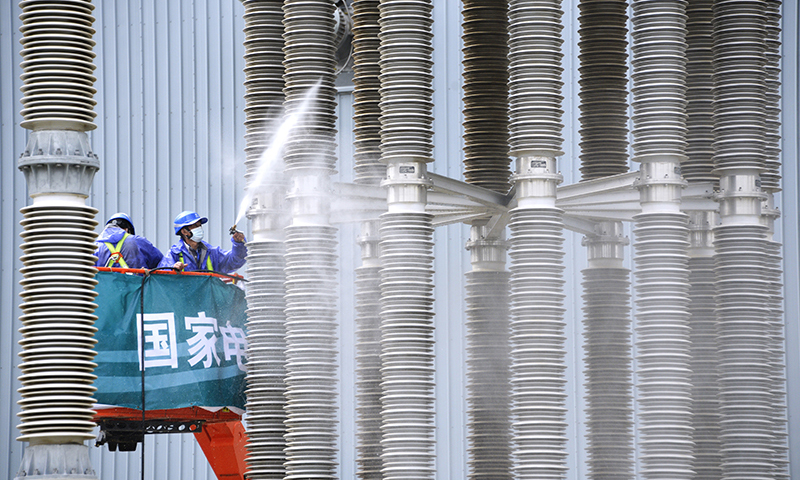 圖為國網(wǎng)北京市電力公司延慶換流站的員工在清洗絕緣立柱。(新華社記者 李欣 攝)