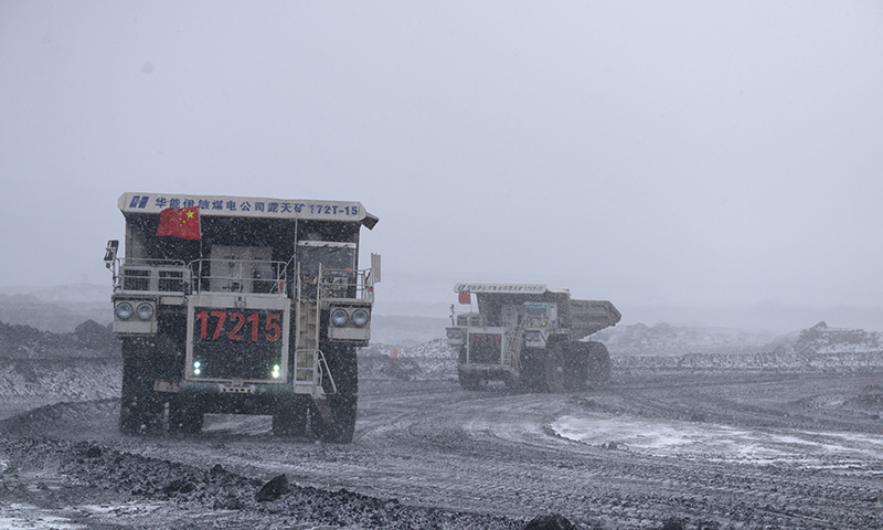 圖為華能伊敏露天礦自卸卡車風(fēng)雪中保煤炭運輸。