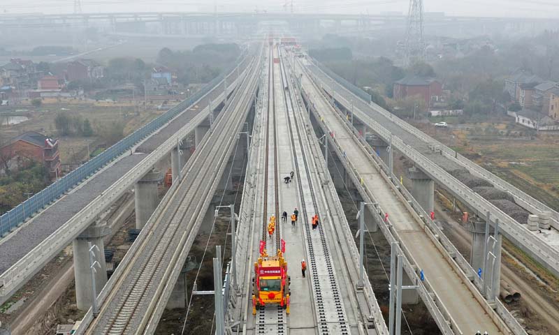 湖杭鐵路設計時速350公里，是“軌道上的長三角”重要節點工程和2022年杭州亞運會重點配套工程。圖為施工人員在湖杭鐵路上進行鋪軌作業（無人機照片）。（新華社記者 黃宗治 攝）