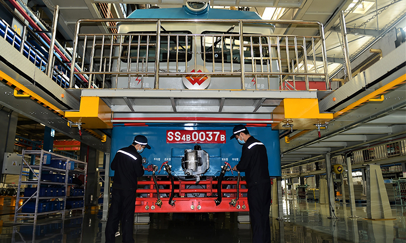 國家能源集團鐵路裝備公司滄州分公司擔負西煤東運第二大通道朔黃鐵路的機車大修任務，這里被形象地稱為“火車醫院”。圖為檢修車間工人進行機車外重聯安裝。（新華社記者 王民 攝）