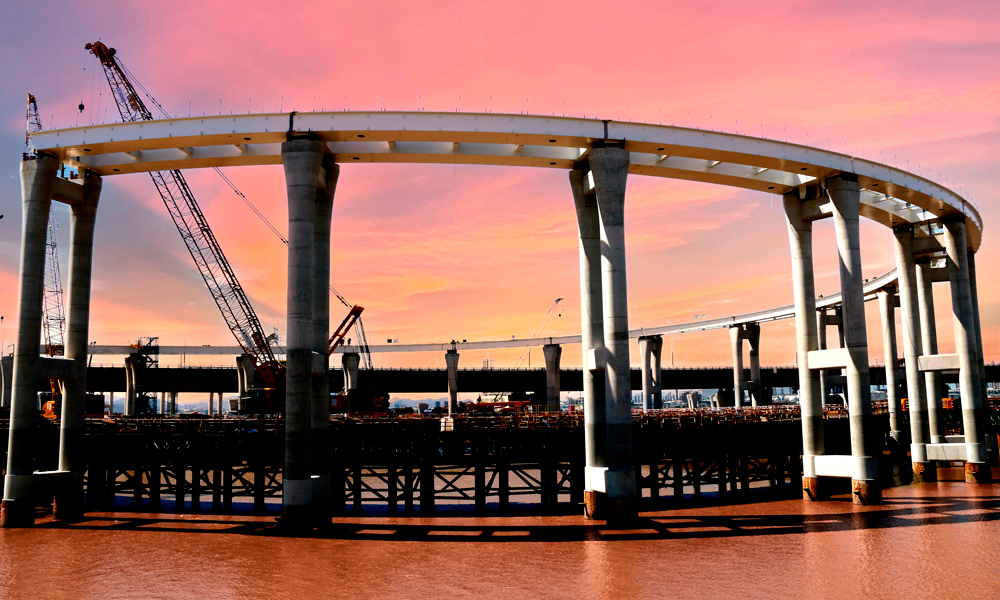 該項目采取棧橋先行的辦法，為鋼護筒運輸、海上加工鋼筋籠、鉆孔泥漿反循環(huán)、插打鋼護筒等搭建了平整、穩(wěn)固的平臺。圖為濱海互通鋼箱梁吊裝作業(yè)現(xiàn)場。