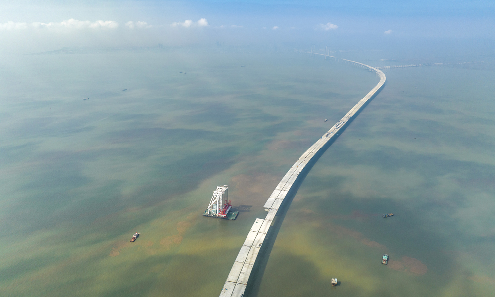 深中通道是集“橋、島、隧、水下互通”于一體的跨海集群工程，全長約24公里。其中海上非通航孔橋共設293片混凝土梁和鋼箱梁。梁體種類多，噸位重，架設精度要求高。本次架設混凝土梁單片長60米、寬20米、高3.5米，重約2800噸，相當于1800輛小轎車的重量，梁體頂部面積相當于3個標準籃球場。圖為11月10日拍攝的深中通道施工現場。