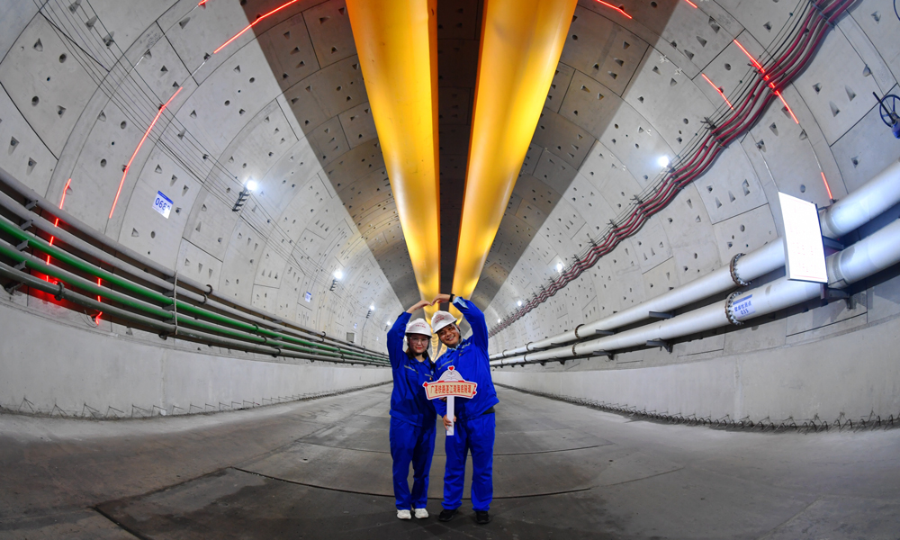 海域段長2500米，最大埋深31米，開挖斷面大，穿越全斷面粉質黏土，刀盤易結泥餅。建設者超前籌劃、精心組織，邀請業內專家對下穿海域段專項施工方案進行反復論證、完善，進行技術上的充分準備。圖為建設者在入海處合影。