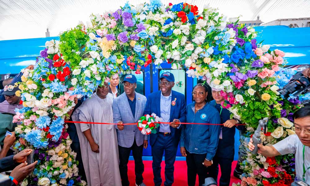 拉各斯輕軌跨lagoon湖高架橋是一座全長557米，水中部分占比超過百分之八十的海上橋梁，同時(shí)也是藍(lán)線輕軌的控制性工程。大橋地處大西洋入海口，面臨深水施工、海工混凝土施工、海底障礙物多等困難，同時(shí)受既有游輪碼頭影響，跨海大橋有效施工時(shí)間短，工期緊張。為破解長聯(lián)大跨、小半徑曲線、橫向風(fēng)荷載下施工穩(wěn)定性、深水施工等難題，建設(shè)者采用剛構(gòu)連續(xù)梁形式跨越水面，與既有公路橋平行對孔布置，歷時(shí)一年零6個(gè)月實(shí)現(xiàn)輕軌跨海運(yùn)行。圖為竣工儀式現(xiàn)場。