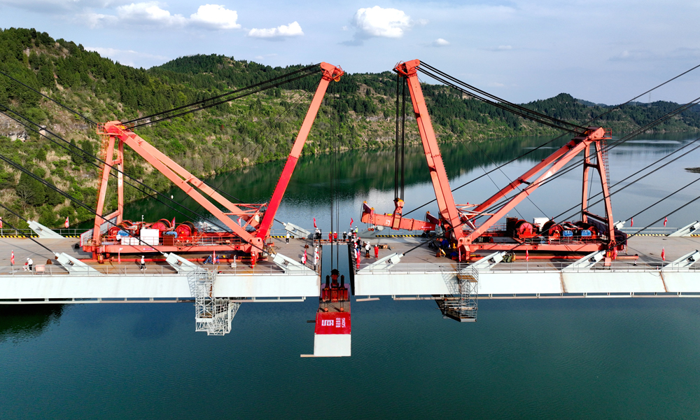 3月31日上午，隨著最后一孔鋼箱梁組件被精準架設至預定位置，標志著由蜀道集團投資建設、中國鐵建所屬鐵五院設計的漢巴南高鐵控制性工程、我國首座雙線高速鐵路高低塔混合梁斜拉橋——嘉陵江特大橋正式合龍。至此，被譽為“紅色高鐵”“出川新蜀道”的漢巴南高鐵全線控制性工程均已打通，為項目如期通車奠定了堅實基礎。圖為嘉陵江特大橋合龍現場。