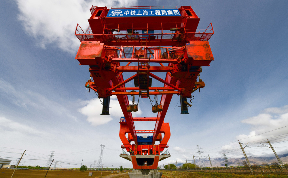 包銀高鐵是國家“八縱八橫”高鐵京蘭通道的重要組成部分，是西北連接?xùn)|北、華北的交通大動(dòng)脈和經(jīng)濟(jì)大通道，也是國家“十四五”規(guī)劃的102個(gè)重大項(xiàng)目之一。項(xiàng)目建成通車后，對(duì)新時(shí)代推進(jìn)西部大開發(fā)、黃河流域生態(tài)保護(hù)和高質(zhì)量發(fā)展等國家戰(zhàn)略具有重大意義。圖為包銀高鐵跨萬甘鐵路特大橋箱梁架設(shè)施工現(xiàn)場(chǎng)。