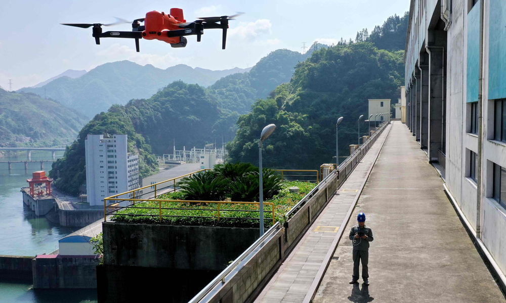 近日，國(guó)家電網(wǎng)湖南水電公司員工操作無人機(jī)巡查柘溪電廠水工建筑物，確保汛期設(shè)備安全。