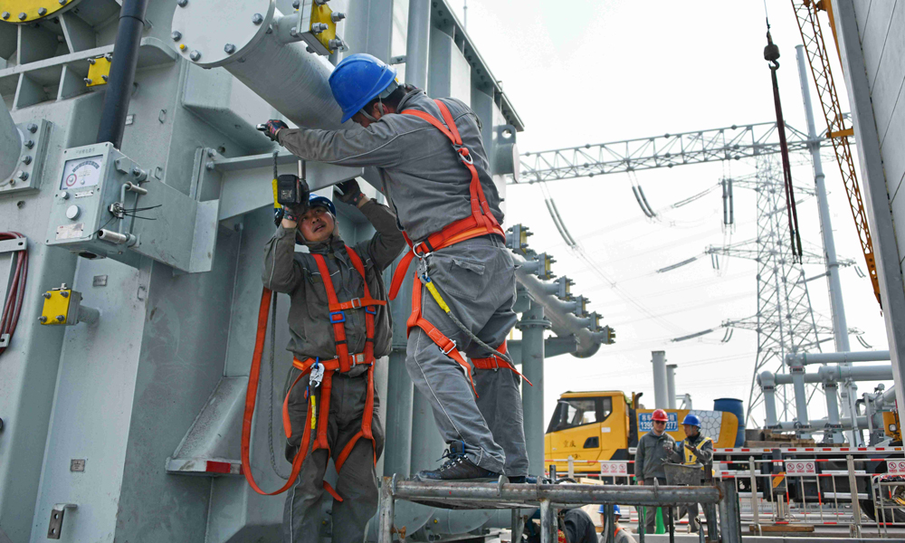 近日，國(guó)家電網(wǎng)重慶送變電公司員工在永川500千伏輸變電工程現(xiàn)場(chǎng)進(jìn)行主變壓器安裝工作，保障迎峰度夏期間電力可靠供應(yīng)。