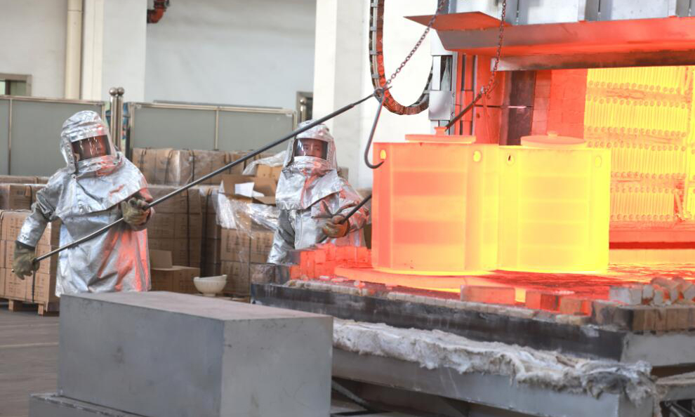 近日，航天科技六院7103廠鑄造車間工作人員將發動機模殼預熱焙燒后轉運砂箱至真空爐，等待澆注。張超 攝