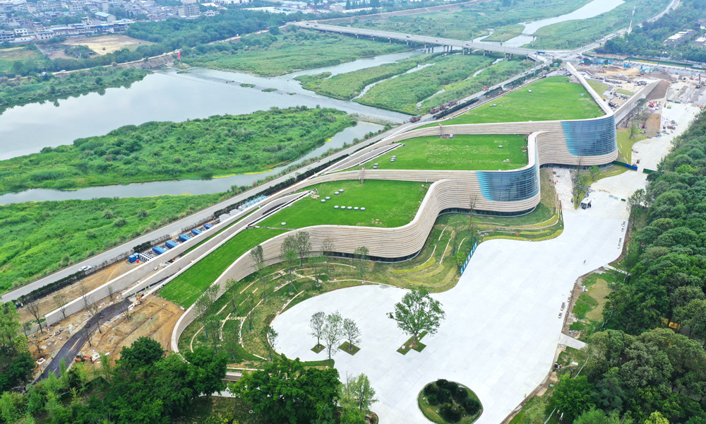 三星堆博物館新館屋頂選用了固化纖維土全種植屋面，綠植種植面積約2.7萬平方米。從空中俯瞰，整個新館與大地融為一體，實現了建筑消隱融于環境的設計初衷。考慮到斜屋面綠化種植特點，建設團隊在建設過程中將植物纖維、有機化合物和營養物質通過微波加熱及機械壓縮形成固化土基質，用于屋面種植。這種基質土層飽水荷載小于45公斤每平方米，可以有效降低屋面覆土荷載，實現了建筑材料從原材料、生產到使用全過程的低碳化，也降低了斜屋面綠植運營養護土壤的營養流失。建設期間，項目還通過太陽能、風能利用，噪音控制、揚塵控制等系統，實現了全過程綠色建造。