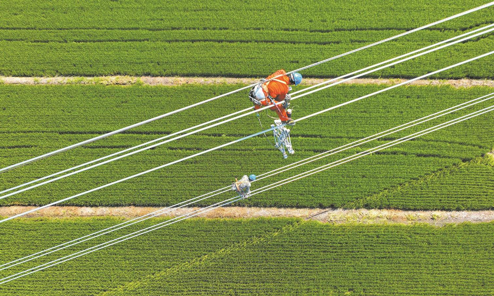近日，國家電網各單位強化電網運行控制，加強設備運維管理，落細負荷管理措施，成功應對高溫、臺風、洪澇災害，保障電力可靠供應。圖為8月23日，國家電網江蘇送變電公司施工人員在±200千伏揚州—鎮江直流輸電線路工程現場架設導線。該工程是我國首個“交流改直流”輸電工程，投運后可增強江蘇電網過江輸電通道的送電能力，將蘇北的綠色電力送至蘇南地區。
