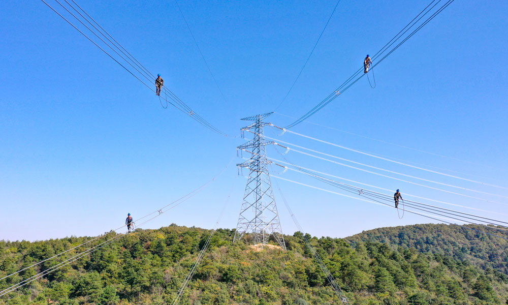 國家電網江蘇省送變電有限公司輸電人員在高空走線驗收消缺。